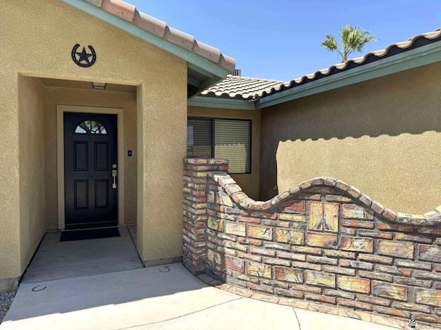 14713 E 52nd Dr, Yuma, AZ 85367 - view of exterior entry with stucco siding and a tiled roof