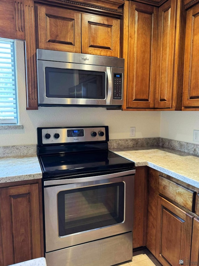 14713 E 52nd Dr, Yuma, AZ 85367 - kitchen with appliances with stainless steel finishes, brown cabinets, and light stone counters