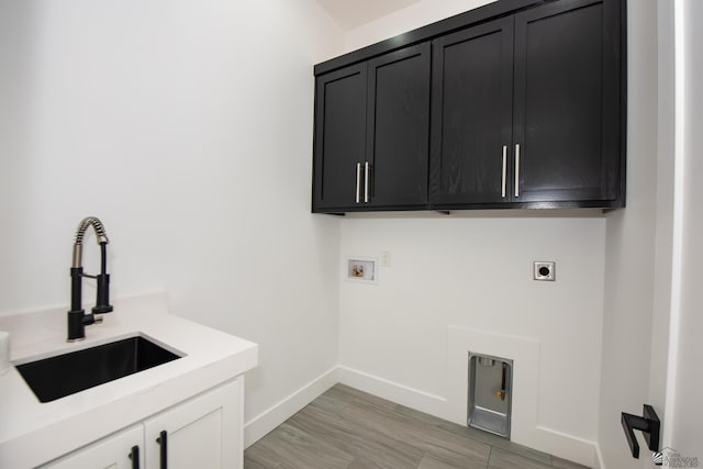 laundry area featuring electric dryer hookup, cabinet space, a sink, baseboards, and hookup for a washing machine