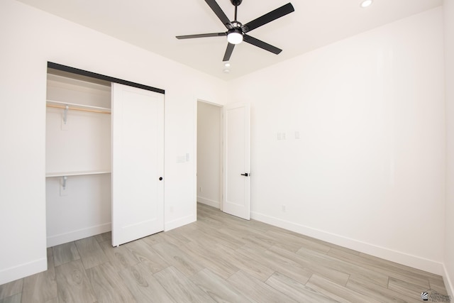 unfurnished bedroom with a closet, baseboards, and light wood-type flooring