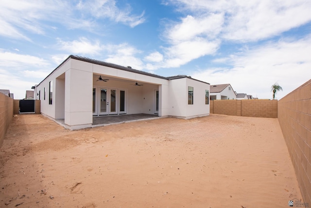 back of property with a fenced backyard, ceiling fan, stucco siding, and french doors