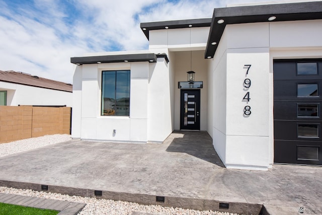 doorway to property with fence and stucco siding