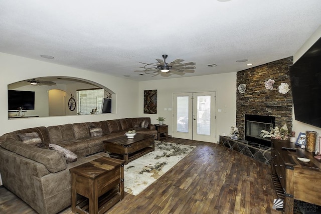 living room with a textured ceiling, french doors, a fireplace, and wood finished floors