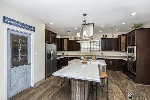 kitchen with dark wood-style floors, light countertops, visible vents, appliances with stainless steel finishes, and dark brown cabinets