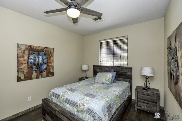 bedroom with dark wood-style floors, a ceiling fan, visible vents, and baseboards