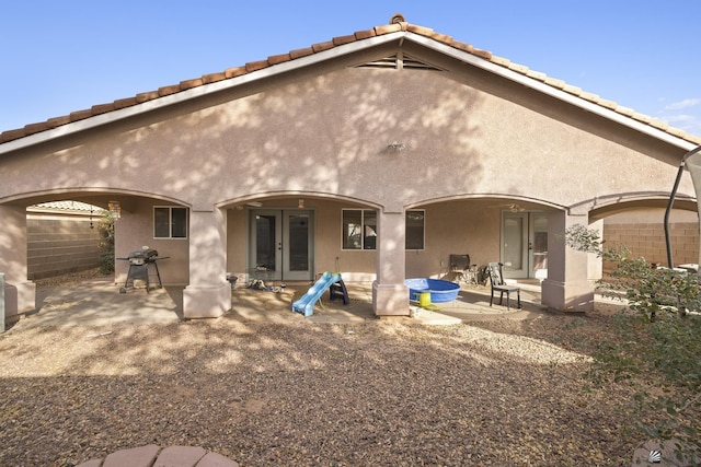 back of property with a patio area, stucco siding, and french doors