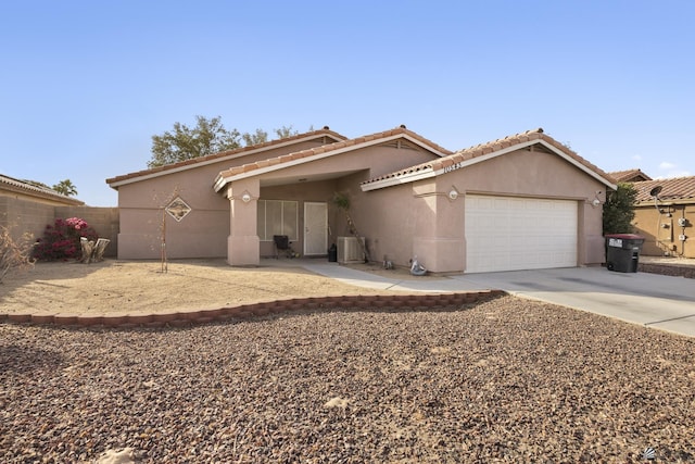 ranch-style home with an attached garage, stucco siding, driveway, and fence