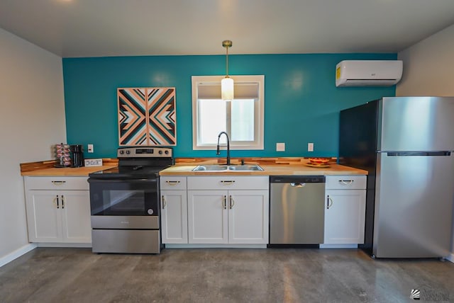 kitchen featuring finished concrete flooring, a wall unit AC, white cabinets, a sink, and stainless steel appliances