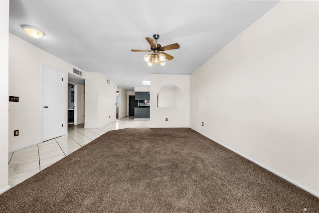 2155 S 14th Ave # 36, Yuma, AZ 85364 - unfurnished living room with visible vents, ceiling fan, light carpet, light tile patterned floors, and baseboards