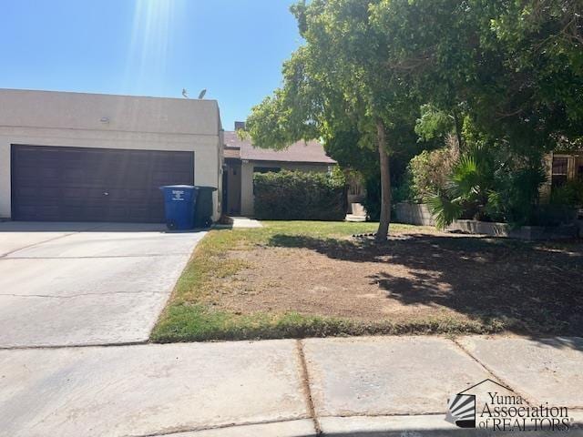 1432 S Sunset Dr, Yuma, AZ 85364 - view of front facade with concrete driveway, stucco siding, and an attached garage