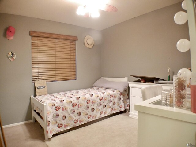 bedroom with light colored carpet and baseboards