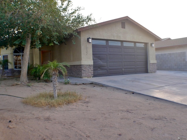 garage featuring concrete driveway