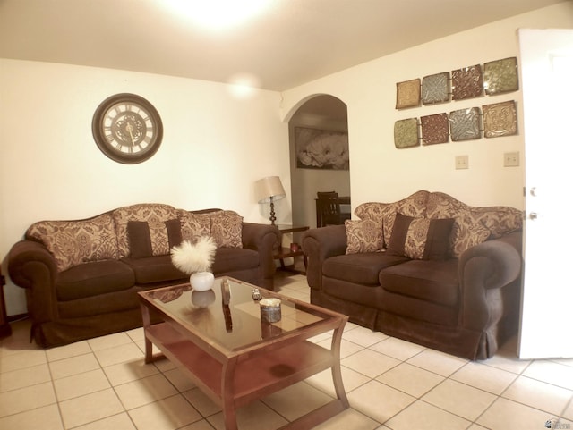living area with arched walkways and light tile patterned flooring