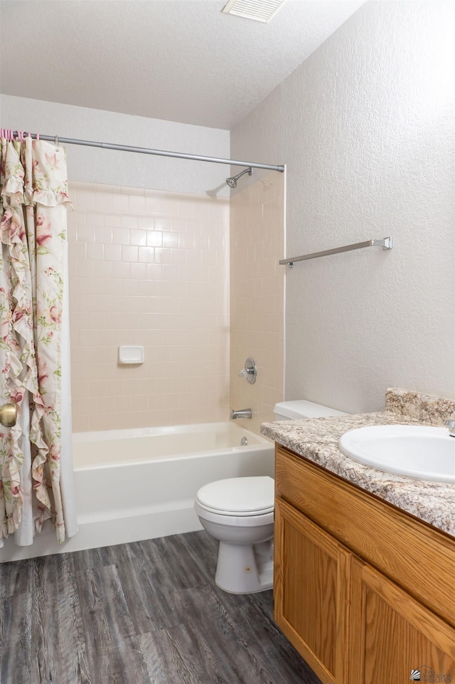 6351 E 41st St, Yuma, AZ 85365 - full bathroom featuring a textured wall, shower / tub combo with curtain, wood finished floors, vanity, and toilet