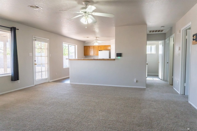 6351 E 41st St, Yuma, AZ 85365 - unfurnished living room featuring ceiling fan, light colored carpet, baseboards, and a textured ceiling