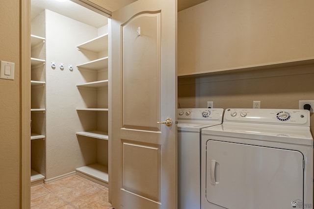 clothes washing area with light tile patterned floors and independent washer and dryer