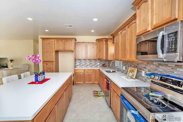 13459 E 43rd Ln, Yuma, AZ 85367 - kitchen with a sink, a center island, stainless steel appliances, tasteful backsplash, and visible vents