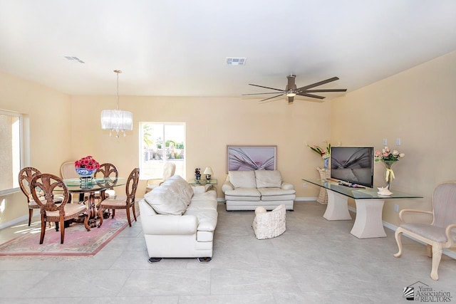 13459 E 43rd Ln, Yuma, AZ 85367 - living room with light tile patterned flooring, baseboards, visible vents, and ceiling fan with notable chandelier