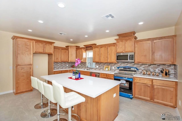 13459 E 43rd Ln, Yuma, AZ 85367 - kitchen featuring appliances with stainless steel finishes, a sink, tasteful backsplash, a kitchen island, and visible vents