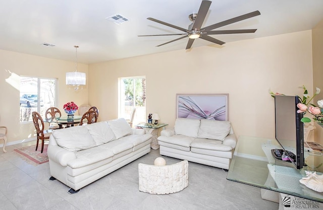13459 E 43rd Ln, Yuma, AZ 85367 - living room with light tile patterned floors, plenty of natural light, ceiling fan with notable chandelier, and visible vents