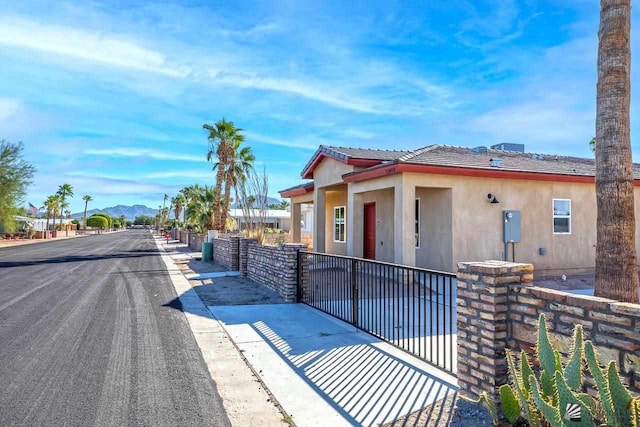 13459 E 43rd Ln, Yuma, AZ 85367 - view of front of home with stucco siding, a mountain view, and fence