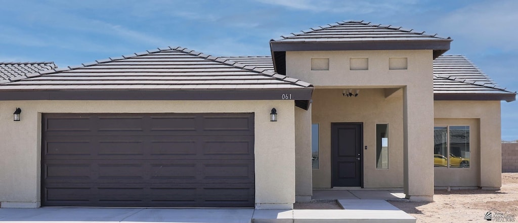 10802 E 45th Pl, Yuma, AZ 85367 - view of front facade featuring an attached garage, a tiled roof, stucco siding, and driveway