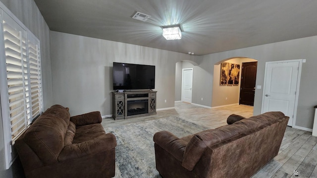 11569 Sonora St, Wellton, AZ 85356 - living room featuring arched walkways, light wood finished floors, baseboards, and a fireplace