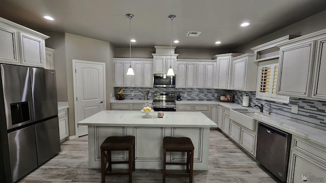 11569 Sonora St, Wellton, AZ 85356 - kitchen with stainless steel appliances, a sink, a breakfast bar area, a center island, and decorative backsplash