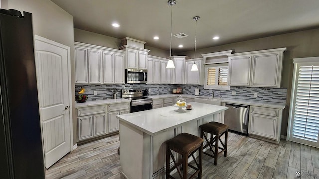 11569 Sonora St, Wellton, AZ 85356 - kitchen with stainless steel appliances, light wood-type flooring, a kitchen breakfast bar, light countertops, and recessed lighting