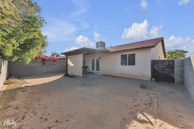 1428 W 15th St, Yuma, AZ 85364 - back of house featuring french doors, a fenced backyard, central AC unit, stucco siding, and a gate