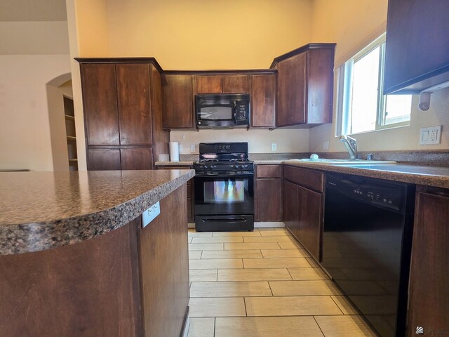 10791 S Sonora St, Yuma, AZ 85367 - kitchen featuring dark brown cabinetry, dark countertops, arched walkways, a sink, and black appliances