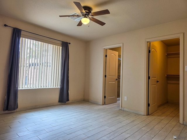 10791 S Sonora St, Yuma, AZ 85367 - unfurnished bedroom featuring light wood-style floors, baseboards, a ceiling fan, and a spacious closet