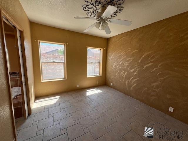 13257 E 55th Dr, Yuma, AZ 85367 - unfurnished room with a ceiling fan and stone finish floor