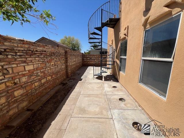 13257 E 55th Dr, Yuma, AZ 85367 - view of home's exterior with a fenced backyard, stairs, stucco siding, and a patio area