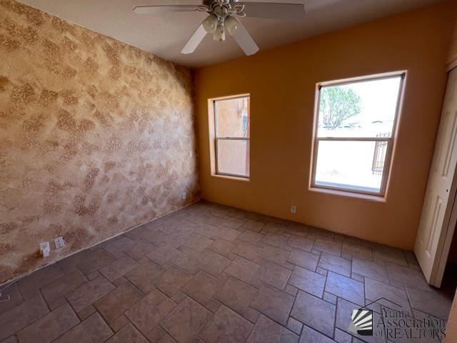 13257 E 55th Dr, Yuma, AZ 85367 - unfurnished room featuring stone tile flooring and ceiling fan