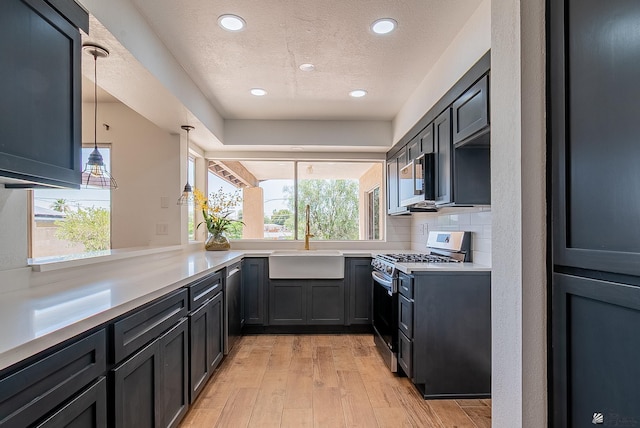 1087 W Palmcroft Dr, Yuma, AZ 85364 - kitchen with stainless steel appliances, light wood-style floors, light countertops, recessed lighting, and a textured ceiling