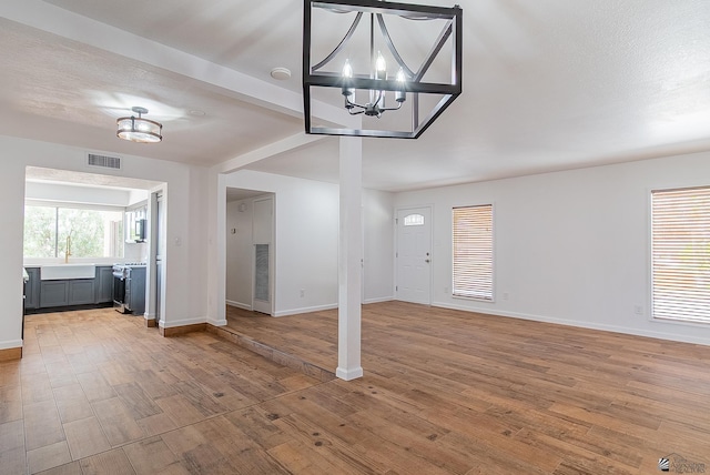 1087 W Palmcroft Dr, Yuma, AZ 85364 - unfurnished living room featuring a chandelier and light wood-style flooring