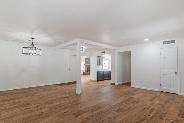 1087 W Palmcroft Dr, Yuma, AZ 85364 - unfurnished living room featuring wood finished floors, recessed lighting, and a chandelier