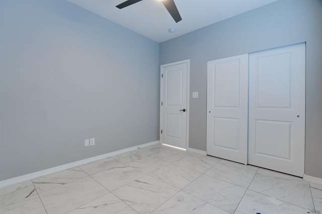 unfurnished bedroom with baseboards, a ceiling fan, a closet, and marble finish floor