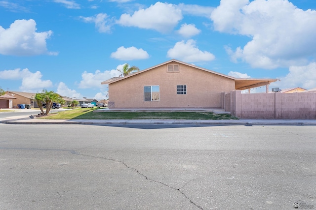 view of property exterior with fence and stucco siding