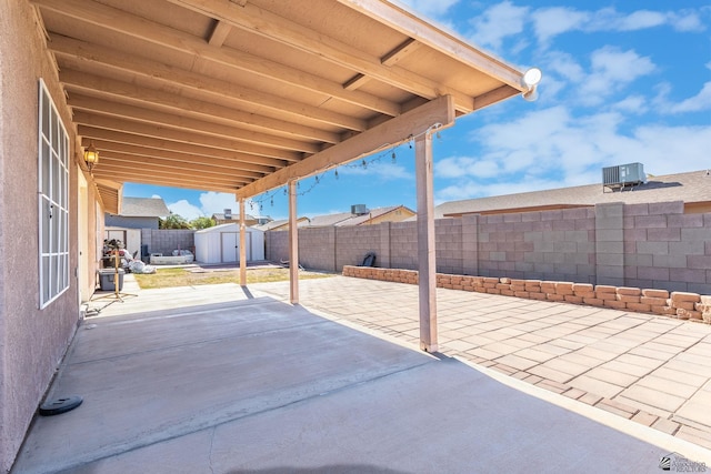 view of patio / terrace featuring a storage shed, an outdoor structure, central AC unit, and a fenced backyard