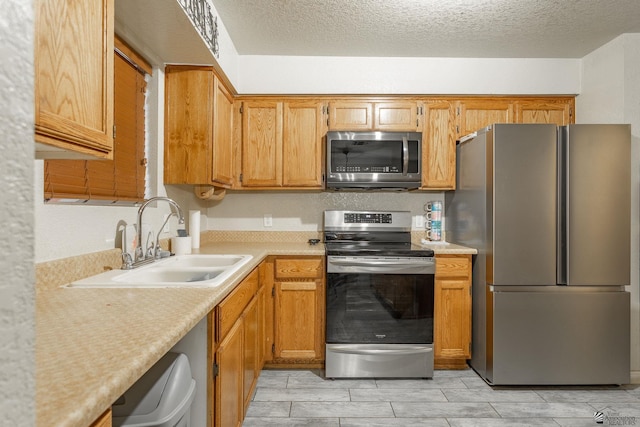 kitchen featuring a sink, appliances with stainless steel finishes, wood finish floors, and light countertops