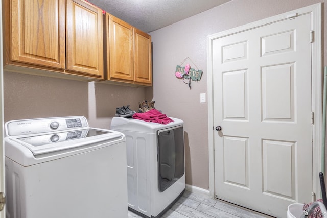 laundry area featuring baseboards, cabinet space, and washing machine and dryer