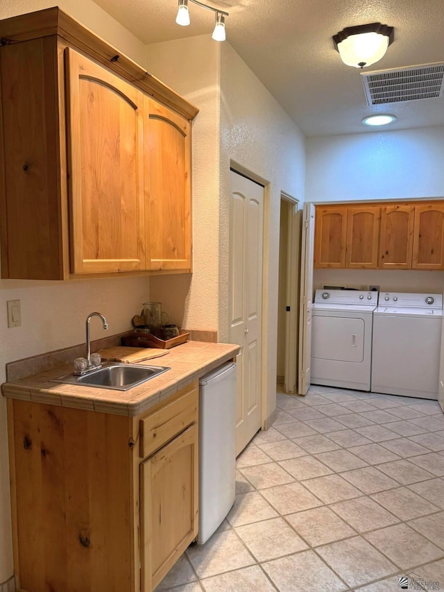 14818 E 52nd St, Yuma, AZ 85367 - kitchen featuring tile countertops, visible vents, washing machine and dryer, dishwasher, and a sink
