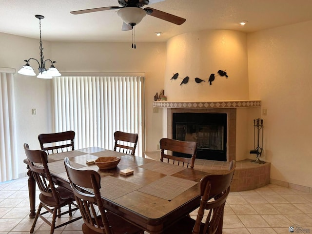 14818 E 52nd St, Yuma, AZ 85367 - dining space with light tile patterned floors, baseboards, a fireplace, and ceiling fan with notable chandelier