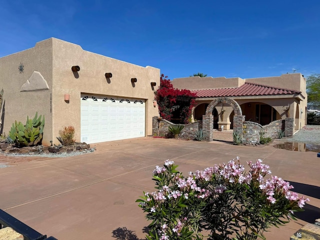 14818 E 52nd St, Yuma, AZ 85367 - pueblo-style home with concrete driveway, a garage, covered porch, and stucco siding
