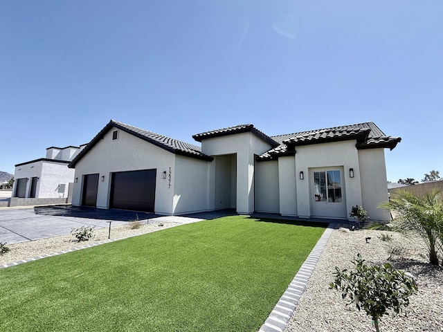 12377 W Calle Ln, Primera, Yuma, AZ 85367 - mediterranean / spanish-style home with a front lawn, a garage, stucco siding, a tiled roof, and driveway