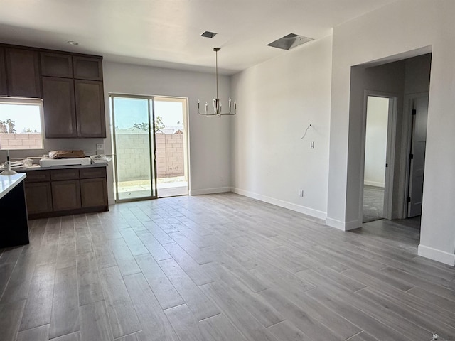 12377 W Calle Ln, Primera, Yuma, AZ 85367 - kitchen featuring light wood-style floors, light countertops, plenty of natural light, and a chandelier
