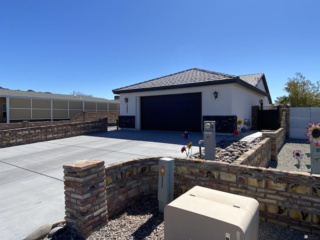 14673 E 52nd St, Yuma, AZ 85367 - view of side of home featuring fence, stucco siding, an attached garage, and driveway