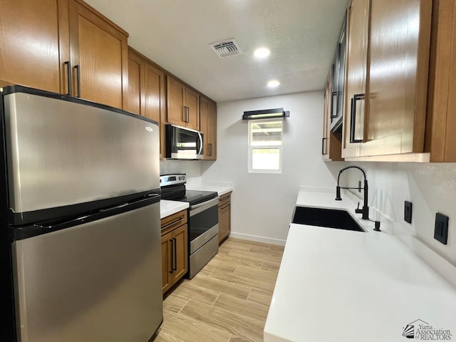2461 S 17th Ave, Yuma, AZ 85364 - kitchen with appliances with stainless steel finishes, brown cabinets, recessed lighting, light countertops, and light wood-type flooring